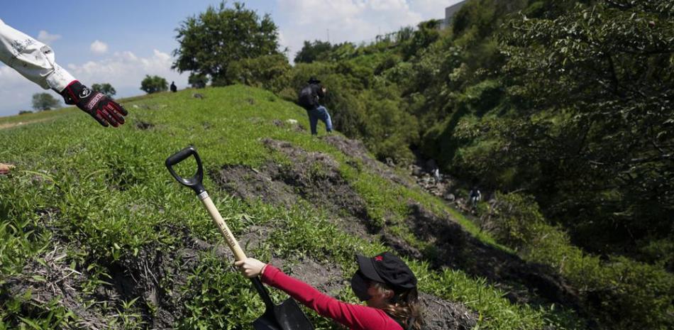 Los voluntarios usan palas mientras buscan en un área los cuerpos de personas desaparecidas en las afueras de Cuautla, México, el martes 12 de octubre de 2021. (AP Foto/Fernando Llano)