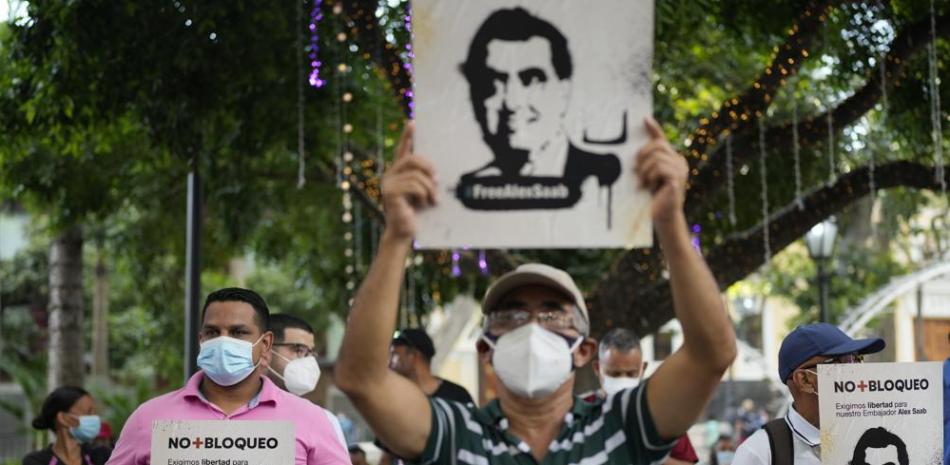 La gente sostiene carteles con la imagen del empresario Alex Saab, quien ha sido extraditado a Estados Unidos, durante una manifestación exigiendo su liberación en Caracas, Venezuela, el domingo 17 de octubre de 2021.   (AP Foto/Ariana Cubillos)