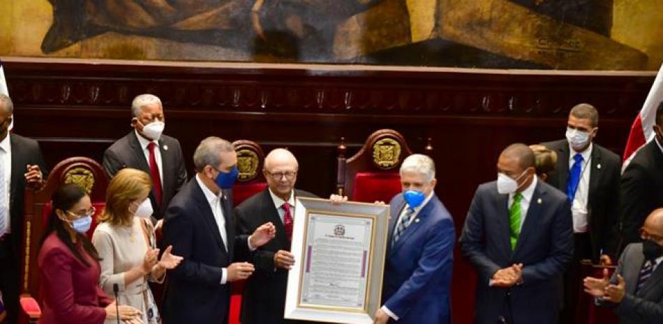 Eduardo Estrella, presidente del Senado, entregando un reconocimiento a Hipólito Mejía.