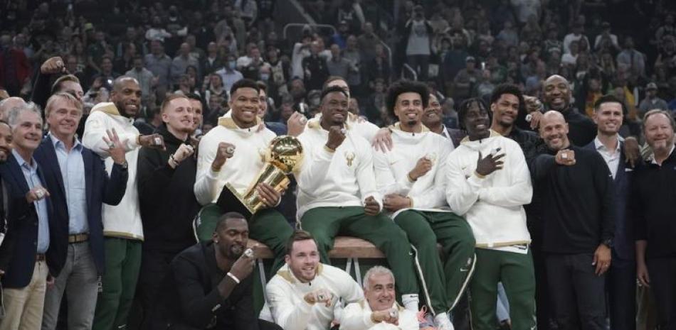Los dueños y jugadores de los Bucks de Milwaukee posan con sus anillos de campeones de la NBA, antes de inaugurar la nueva temporada.