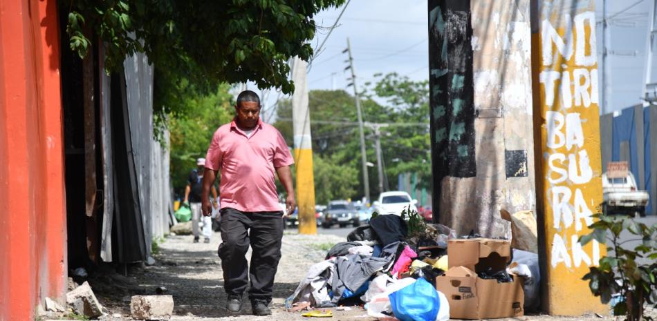 Hombre camina próximo a basura acumulada. / Foto: Raúl Asencio