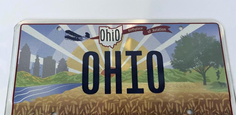 El gobernador de Ohio, Mike DeWine, presentó el jueves 21 de octubre de 2021 la nueva placa de matrícula "Sunrise in Ohio" en Columbus, Ohio. La nueva placa de Ohio no despegó después de que la ilustración de una pancarta en vuelo se colocara en el extremo equivocado del primer avión de los hermanos Wright. El letrero de la nueva placa dice "Lugar de nacimiento de la aviación". La pancarta debería haber estado detrás del avión, pero estaba pegada al frente. (Jessie Balmert / The Cincinnati Enquirer vía AP)