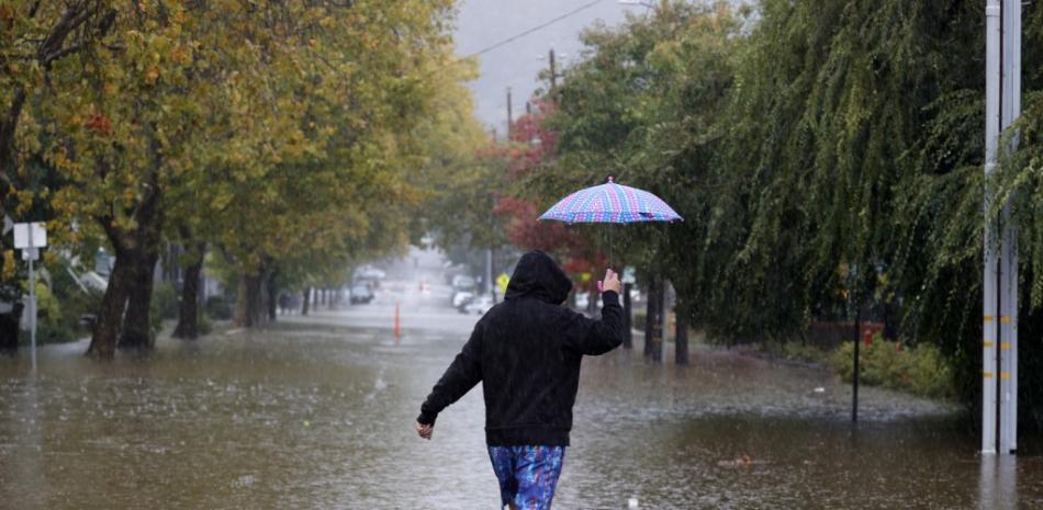 Un peatón lleva un paraguas mientras camina por una calle inundada el 24 de octubre de 2021 en San Rafael, California.  Justin Sullivan / Getty Images / AFP
JUSTIN SULLIVAN / GETTY IMAGES NORTEAMÉRICA / Getty Images vía AFP