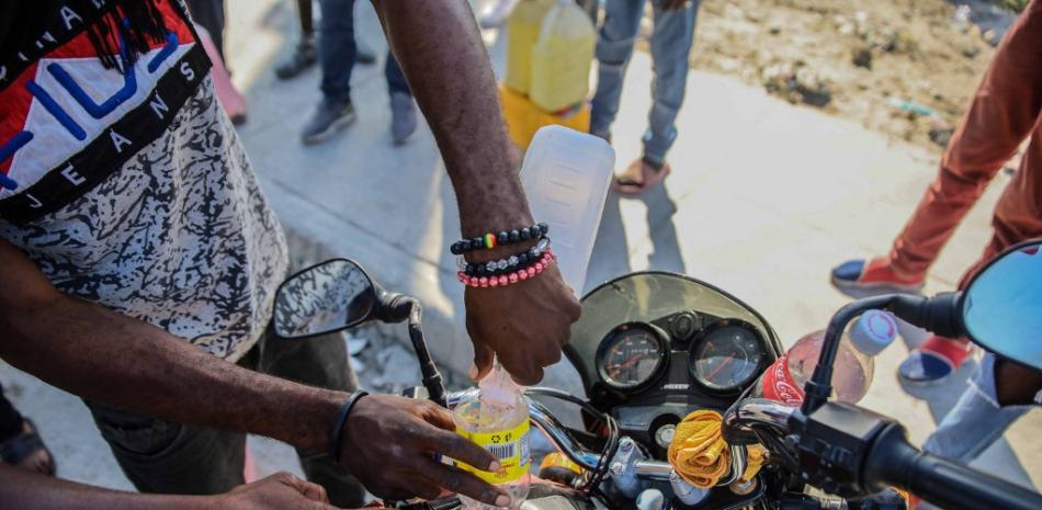 Las personas que compraron gasolina en Santo Domingo la revenden en Haití durante una huelga general y falta de transporte, en medio de una escasez de combustible en Puerto Príncipe, Haití, el 26 de octubre de 2021. Si no pueden encontrar combustible para comprar en el país , algunos haitianos van a la vecina República Dominicana a comprarlo. Algunos luego revenden el preciado recurso en Puerto Príncipe en el mercado negro a tasas hasta diez veces superiores al precio legal, explicaron a un fotógrafo de AFP. Richard PIERRIN / AFP