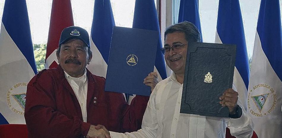 Presidente nicaragüense Daniel Ortega (izq.) Y el presidente hondureño Juan Orlando Hernández se dan la mano luego de la firma del Tratado de Integración Bicentenario en Managua el 27 de octubre de 2021.
Presidencia de Honduras / AFP