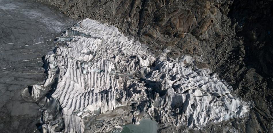 Esta vista aérea tomada el 27 de octubre de 2021 cerca de Gletsch muestra una espuma aislante que cubre una parte del glaciar Rhone para evitar que se derrita debido al calentamiento global. Los glaciares suizos perdieron el 1% de su volumen en 2021, a pesar de las fuertes nevadas y un verano fresco, debido al cambio climático. Foto: Fabrice Coffrini/AFP.