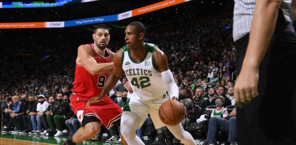 Al Horford, de los Celtics de Boston, maneja el balón frente a la defensa de Nikola Vucevic, de los Bulls de Chicago, en acción del partido del lunes en la NBA.