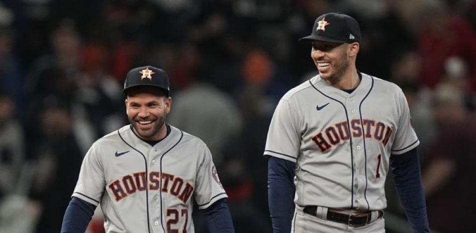 El segunda base José Altuve y su compañero de los Astros, Carlos Correa, sonríen después de ganar el quinto juego de la Serie Mundial ante los Bravos de Atlanta.