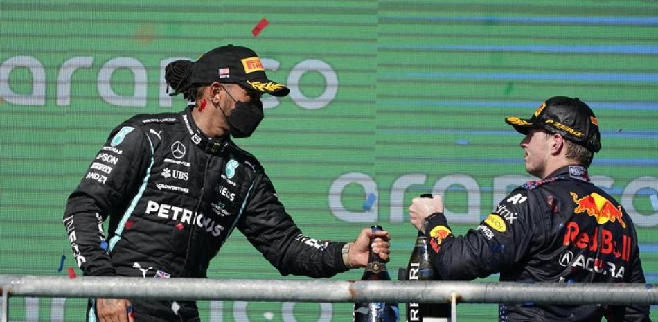 Lewis Hamilton (izq) y Max Verstappen hacen a un lado la animosidad que los separa y se saludan en el podio tras el GP de EEUU en el Circuito de las Américas en Austin.