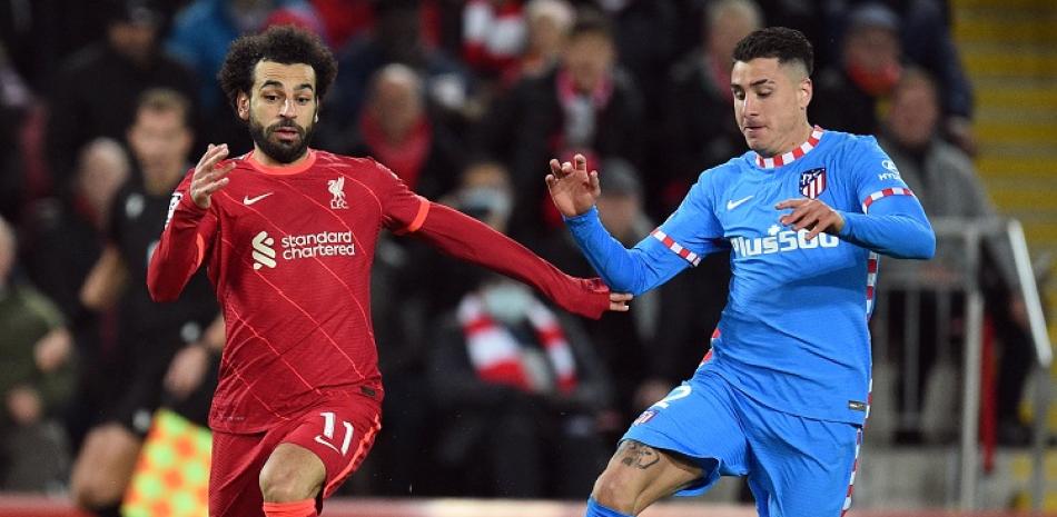 Mohamed Salah, del Liverpool, a la izquierda, lucha por controlar el balón con el defensor del Atletico de Madrid Jose Gimenez en el partido de la Liga de Campeones.
