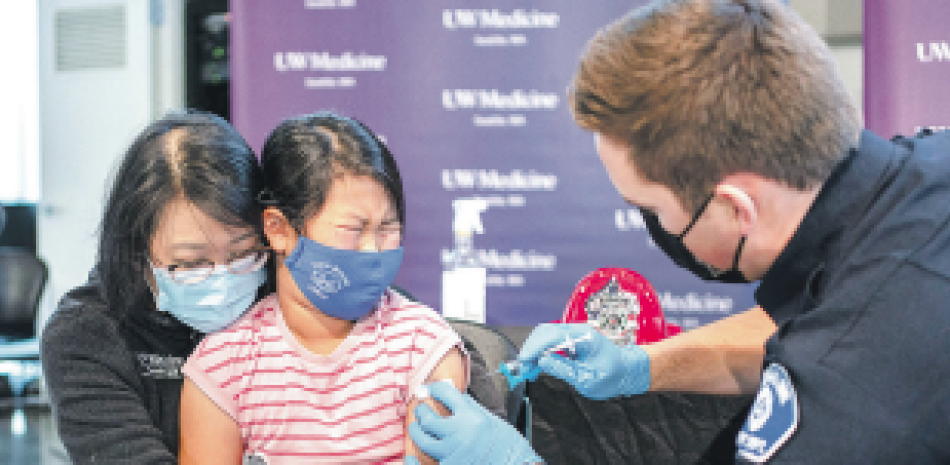 Lise Wong, de 7 años, cuando era vacunada. / AFP