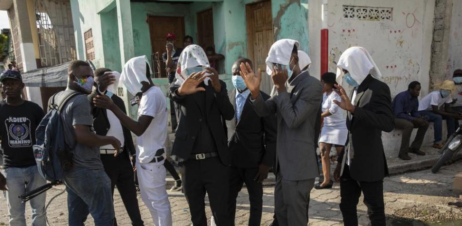 Miembros de una pandilla utilizan toallas para ocultar su identidad a su llegada al funeral por su compañero Tonino Manino, en Puerto Príncipe, Haití, el 30 de septiembre de 2021. Foto: AP/Rodrigo Abd.