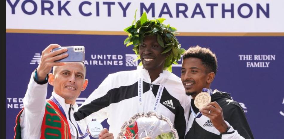 Los ganadores del Maratón de Nueva York, Albert Korir, de Kenia, al centro, Mohamed Reda El Aaraby, de Marruecos, a la izquierda, y Eyob Faniel, de Italia, posan en el podio.