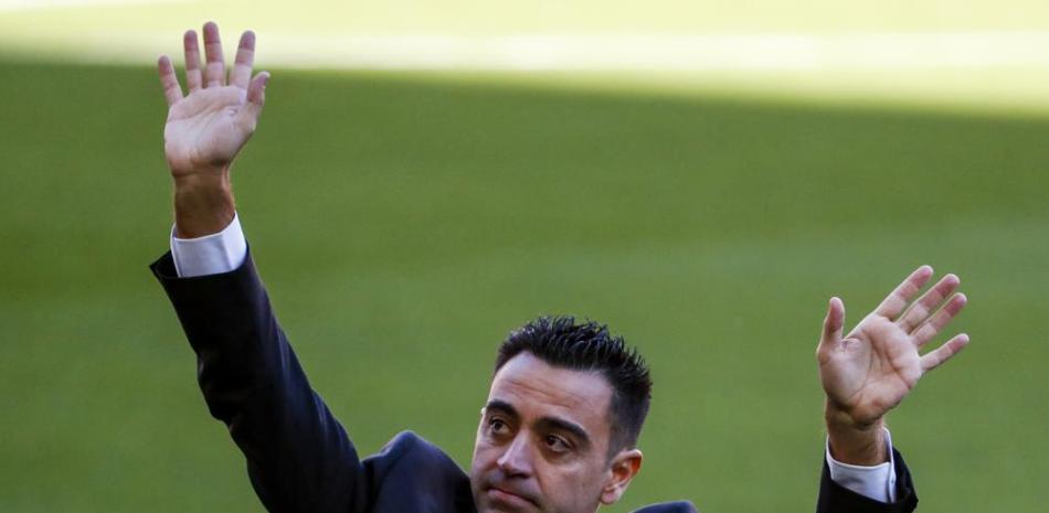 El nuevo técnico del Barcelona Xavi Hernández saluda al público en su presentación oficial.