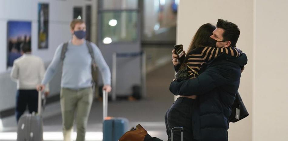 Natalia Abrahao es alzada por su prometido Mark Ogertsehnig mientras ambos se abrazan en el aeropuerto internacional Newark Liberty en Newark, Nueva Jersey, el lunes 8 de noviembre de 2021. (AP Foto/Seth Wenig)