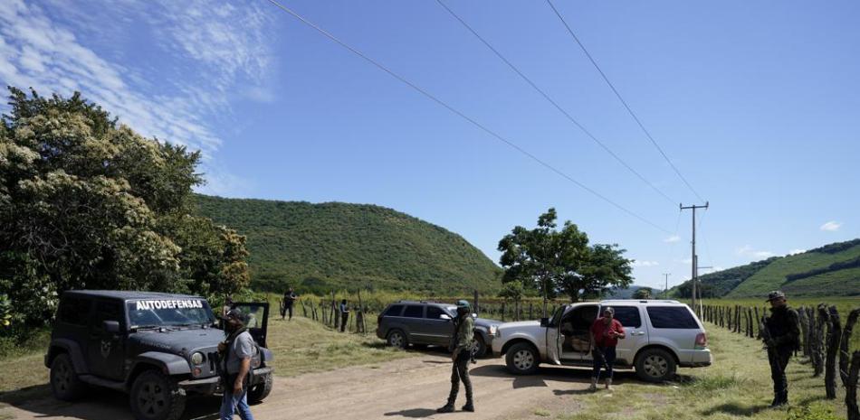 Individuos que dicen pertenecer a una fuerza de "autodefensa" vigilan una carretera de acceso a Taixtán, estado mexicano de Michoacán, el 28 de octubre del 2021. (AP Photo/Eduardo Verdugo)