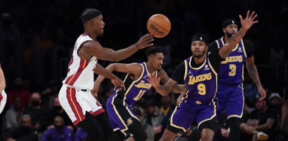 El jugador del Heat de Miami Jimmy Butler (22) pasa la pelota ante Kent Bazemore (9), de los Lakers de Los Ángeles, en la primera mitad del juego de la NBA.