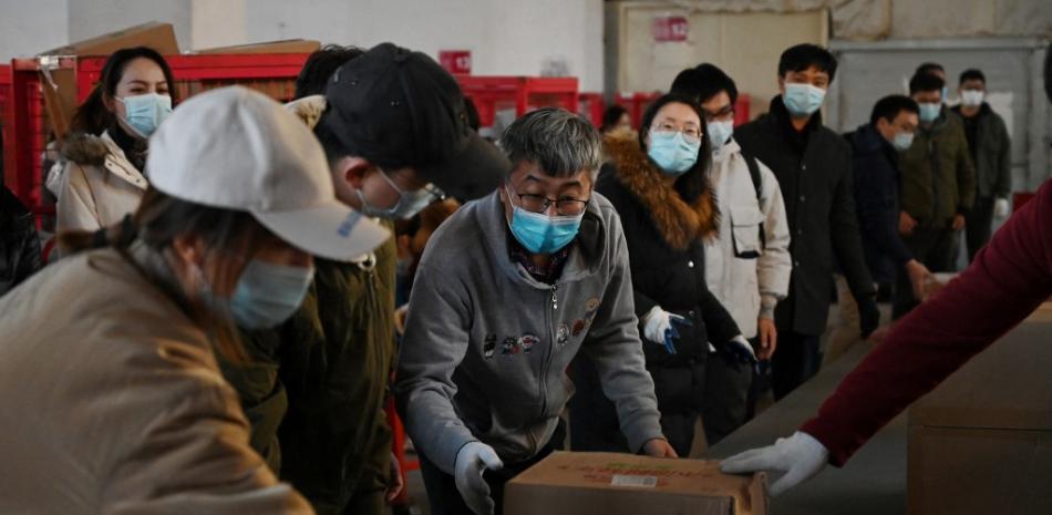 Empleados clasifican los paquetes para entregarlos en un centro de distribución de JD.com en el "Día de los solteros", también conocido como el Doble 11, el día de compras más grande del año, en Beijing el 11 de noviembre de 2021. Foto: Greg Baker/AFP.