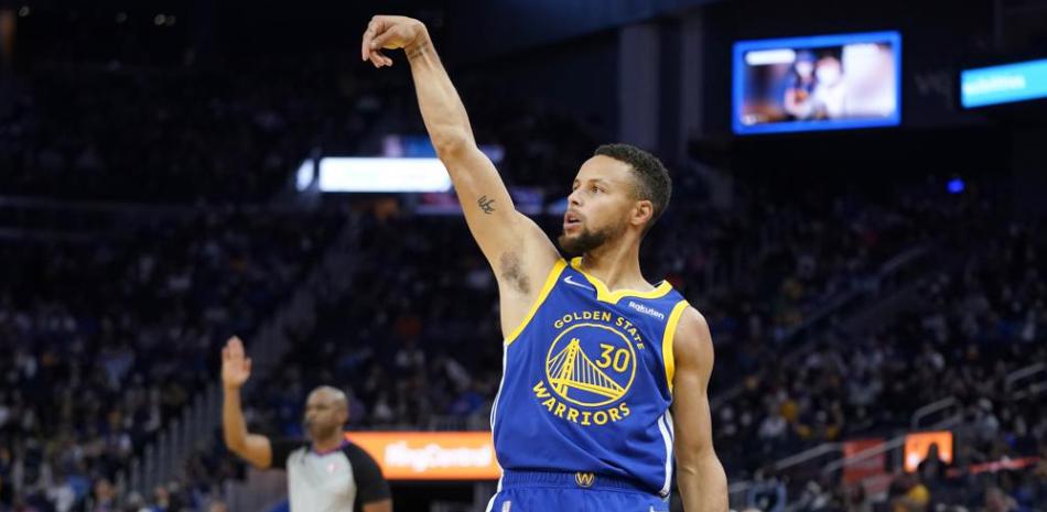 El jugador de los Warriors de Golden State Stephen Curry reacciona tras lanzar un triple en la segunda mitad del juego de la NBA que enfrentó a su equipo con los Bulls de Chicago, en San Francisco.