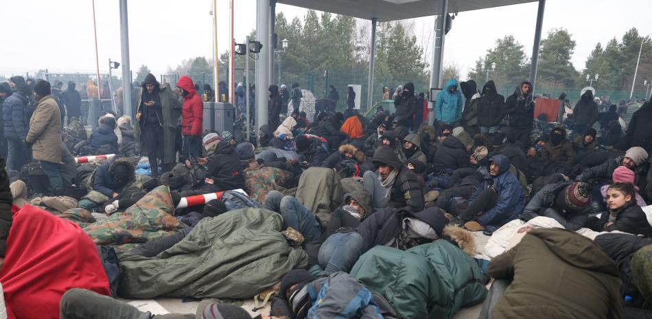 Los migrantes se reúnen en la frontera bielorrusa-polaca cerca del paso fronterizo polaco de Kuznica el 15 de noviembre de 2021. Miles de migrantes, la mayoría de ellos de Oriente Medio, han cruzado o intentado cruzar la frontera de la UE y la OTAN desde el verano. // AFP