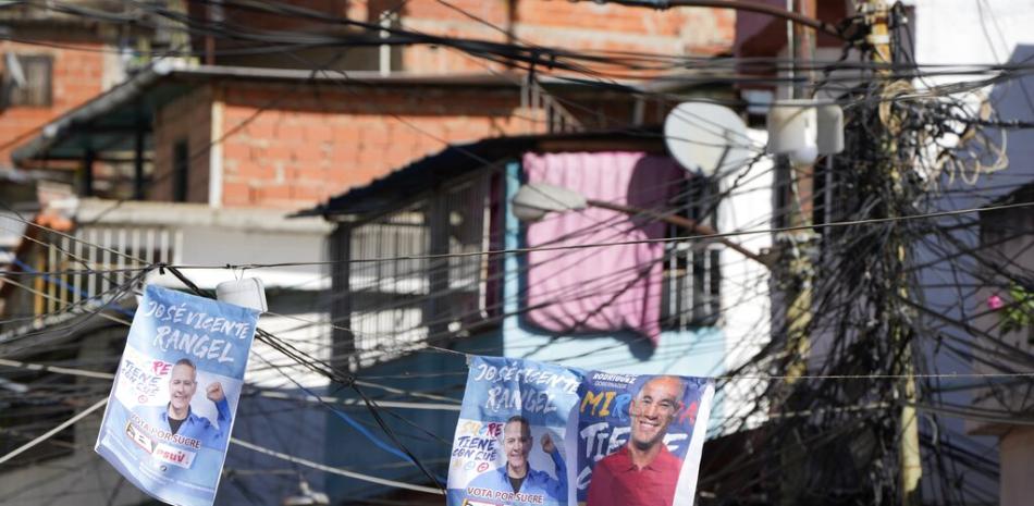 Carteles de candidatos del partido en el gobierno, Miranda Héctor Rodríguez, a la deecha, y del aspirante a la alcaldía de Sucre, José Vicente Rangel, colgados en una calle en Caracas, el viernes 19 de noviembre de 2021.

Foto: AP/Ariana Cubillos