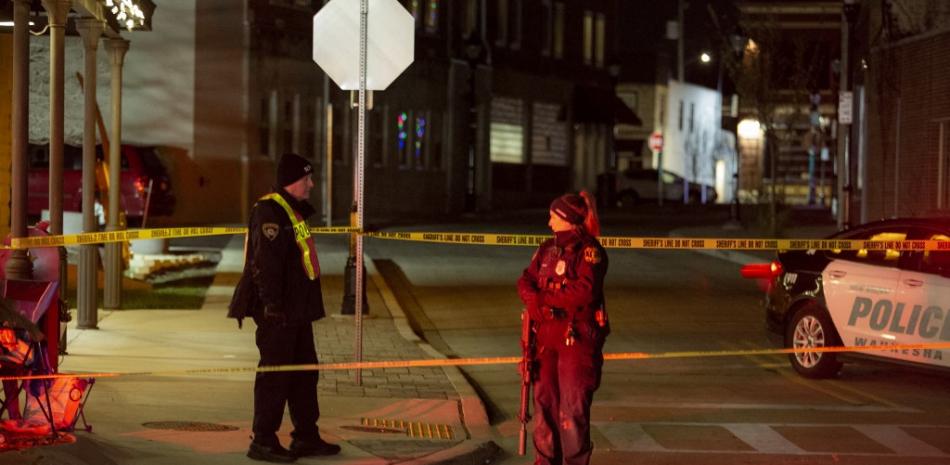 La policía y el personal de emergencia trabajan en la escena del crimen el 21 de noviembre de 2021 en Waukesha, Wisconsin. Según los informes, una camioneta atravesó a los peatones en un desfile festivo, matando al menos a uno e hiriendo a 20 más. Jim Vondruska / Getty Images / AFP
