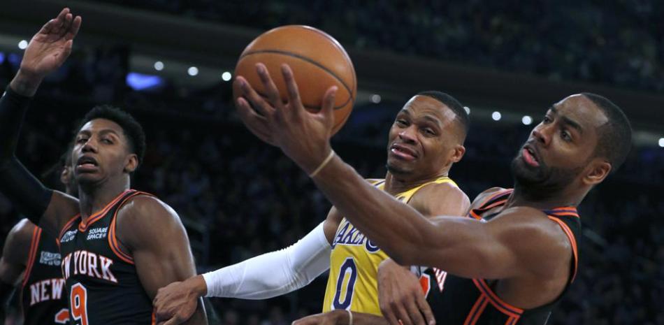 El base de los Lakers de Los Ángeles Russell Westbrook y el escolta de los Knicks de Nueva York Alec Burks buscan el rebote durante la primera mitad del partido de la NBA, el martes 23 de noviembre de 2021, en Nueva York.