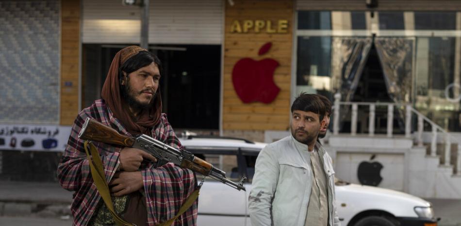 Un hombre afgano observa a un combatiente talibán que hace guardia en un puesto de control, en Kabul, Afganistán, el miércoles 17 de noviembre de 2021. Ha habido varios atentados con bombas contra vehículos en Kabul en los últimos días.

Foto: AP / Petros Giannakouris