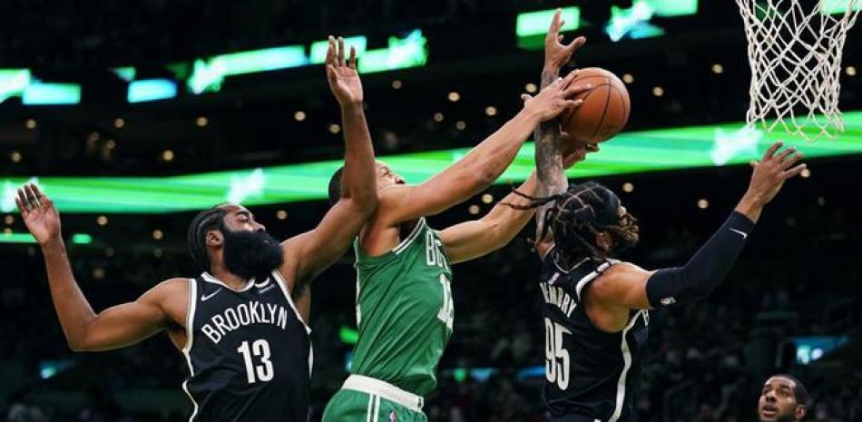 El alero de los Celtics de Boston Grant Williams, disputa un rebote ante el escolta de los Nets de Brooklyn, DeAndre 'Bembry, en la primera mitad del juego del miércoles 24 de noviembre de 2021, en Boston. A la izquierda aparece el base de los Nets, James Harden.
