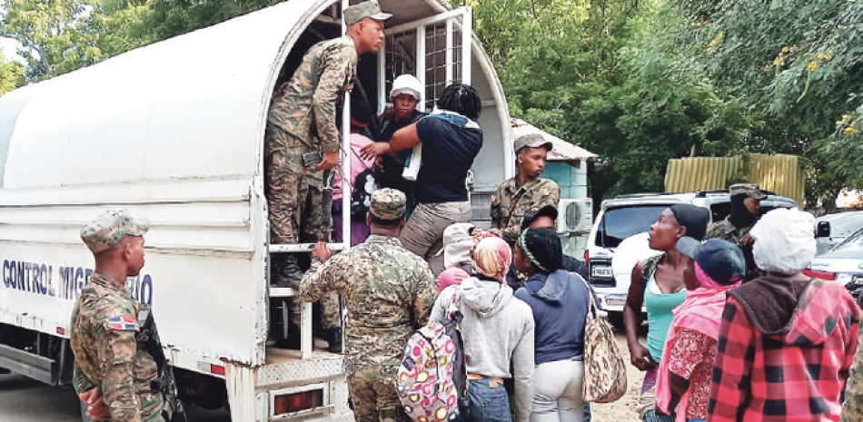 Fuerzas militares montan a haitianos ilegales en una unidad del Servicio de Control Migratorio, tras su captura en pueblos de la frontera, para su repatriación a Haití.
