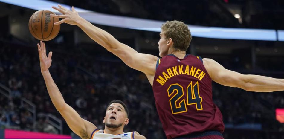 Devin Booker, de los Suns de Phoenix, dispara ante la defensa de Lauri Markkanen, de los Cavaliers de Cleveland, en la primera mitad del juego del miércoles 24 de noviembre de 2021, en Cleveland.