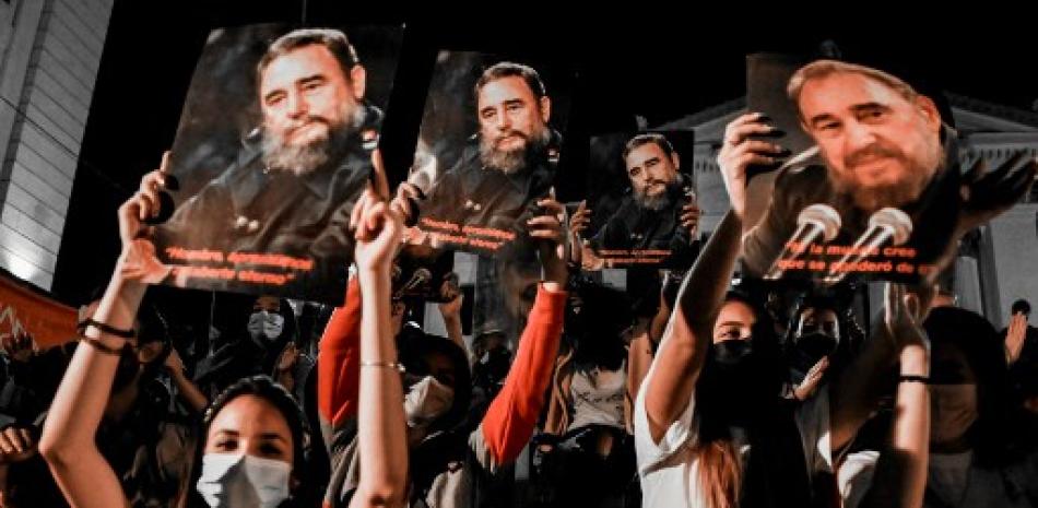 Jóvenes sostienen carteles del fallecido líder cubano Fidel Castro durante la vigilia por el quinto aniversario de su desaparición física en La Habana, el 24 de noviembre de 2021 // AFP