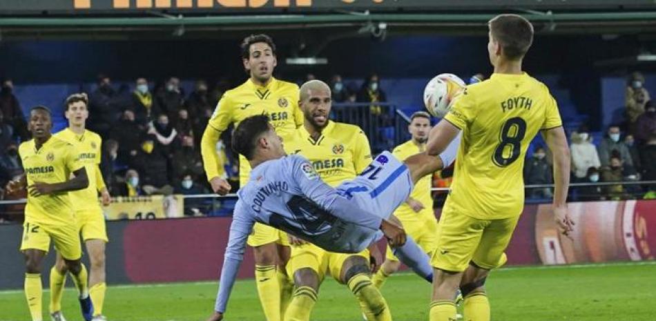 Philippe Coutinho, del Barcelona, al centro, intenta anotar de tijera durante el partido contra Villarreal, en Villareal, España.