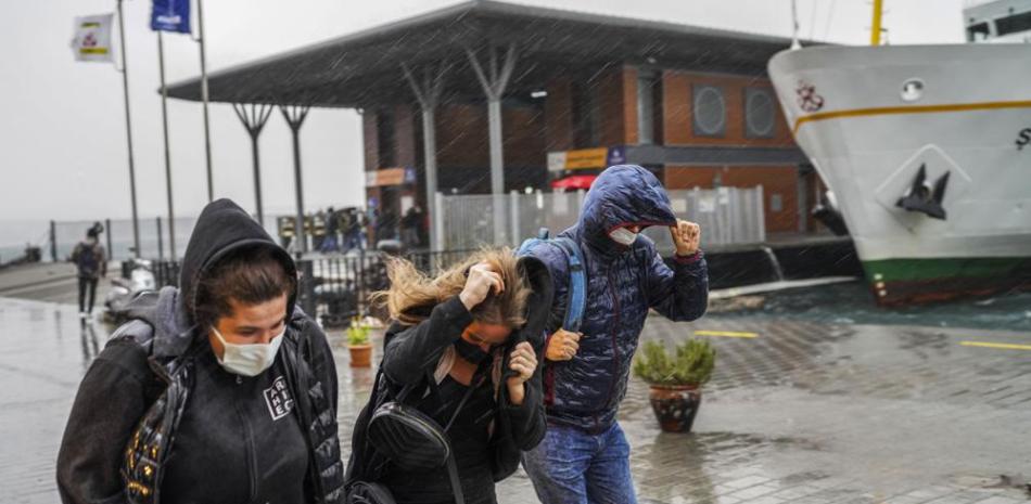 La gente corre bajo una intensa lluvia durante un día tormentoso en Estambul. Foto AP