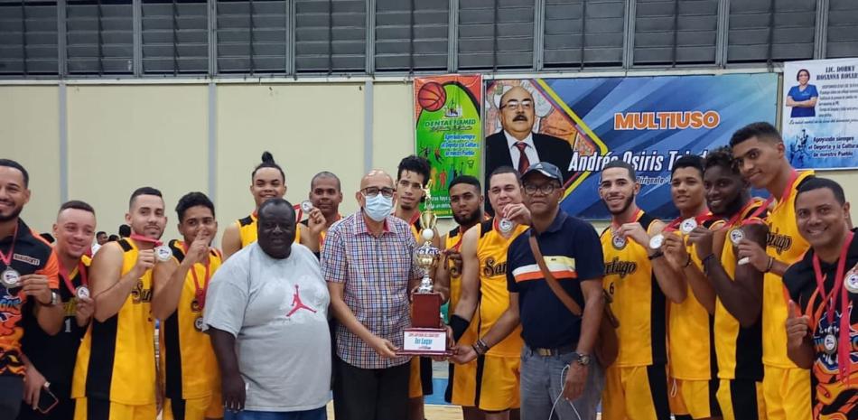 Edward Rojas, acompañado por sus compañeros, el dirigente Roberto Balbuena y José --Yeye-- Aybar, presidente de la Asociación de Voleibol de Santiago, recibe la copa de campeón de manos de Nelson Ramírez, secretario de Fedovoli.