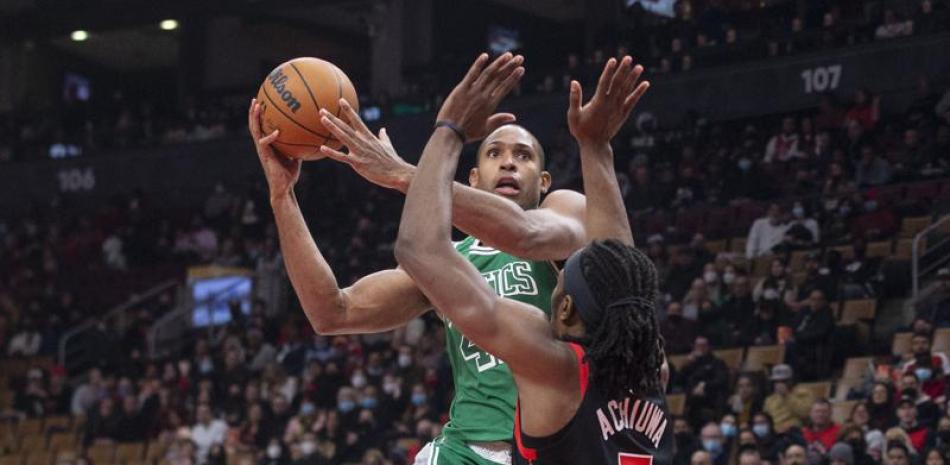 Al Horford de los Celtics de Boston salta para anotar mientras lo defiende Precious Achiuwa de los Raptors de Toronto en el encuentro del domingo 28 de noviembre de 2021.
