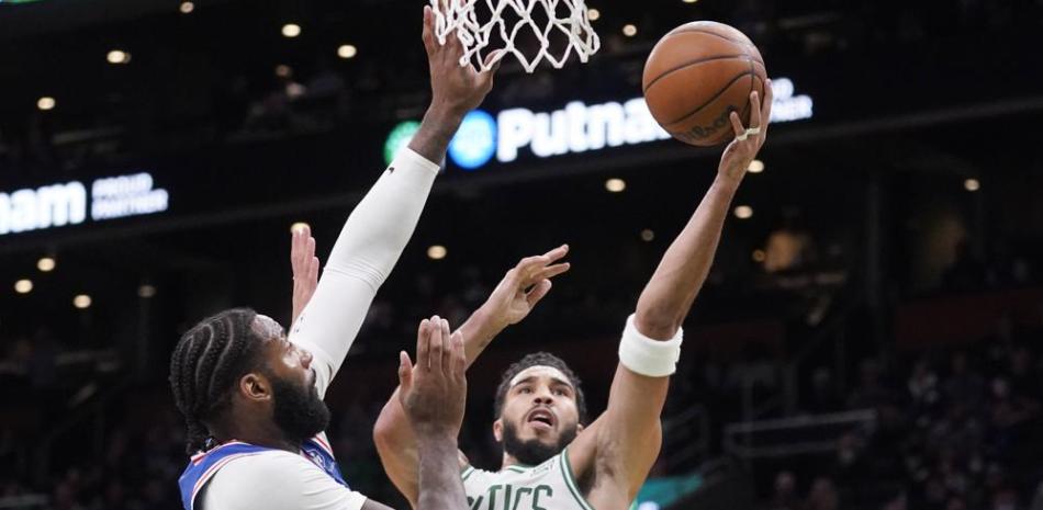 El alero de los Celtics de Boston Jaysum Tatum ataca el canasto ante el pívot de los 76ers de Filadelfia, Andre Drummond, en la primera mitad del juego del miércoles 1 de diciembre de 2021, en Boston.