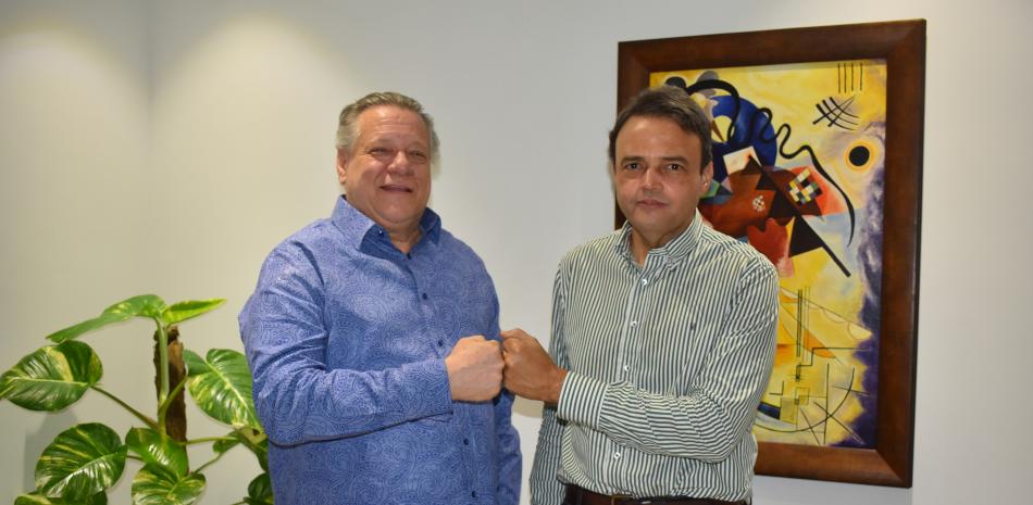 Arístides Fernández Zucco y José Manuel Ramos, promotores de la ciudad de Santo Domingo como sede de los Juegos Centroamericanos y del Caribe de 2026, chocan sus puños durante una visita a El Deporte de Listín Diario.