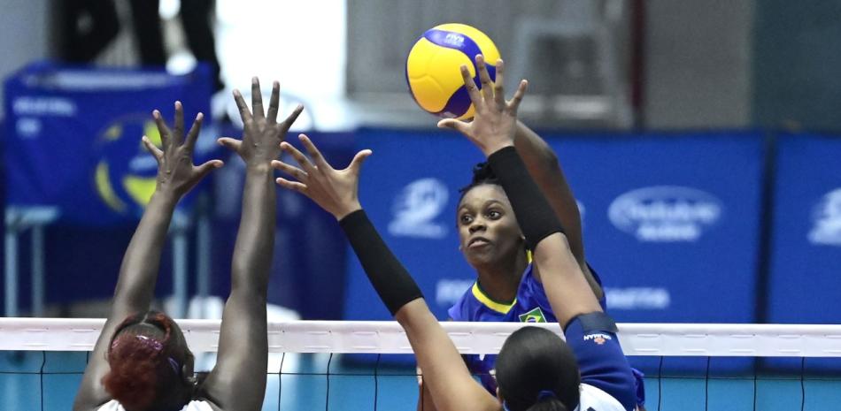 Lorrayne Marys De Silva, de Brasil, ataca ante la defensa sobre la red de dos jugadoras de República Dominicana.