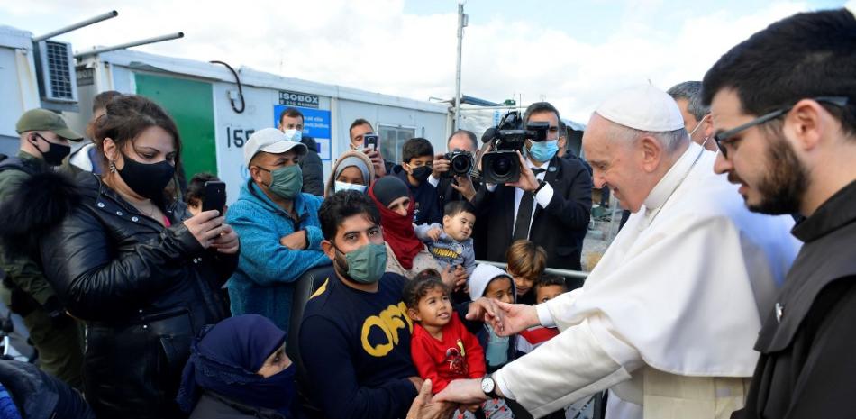 Esta fotografía del folleto tomada el 5 de diciembre de 2021 y publicada por Vatican Media muestra al Papa Francisco (2R) reuniéndose con refugiados en el Centro de Recepción e Identificación en Mitilene en la isla de Lesbos. MEDIOS VATICANOS / AFP