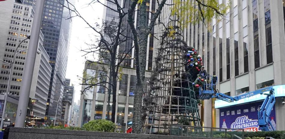 Un trabajador desmonta un árbol de Navidad frente a la sede de Fox News en Nueva York el miércoles 8 de diciembre de 2021. La policía dice que un hombre enfrenta cargos que incluyen incendio provocado por prender fuego al árbol de Navidad de 50 pies en Manhattan. (Foto AP/Richard Drew)