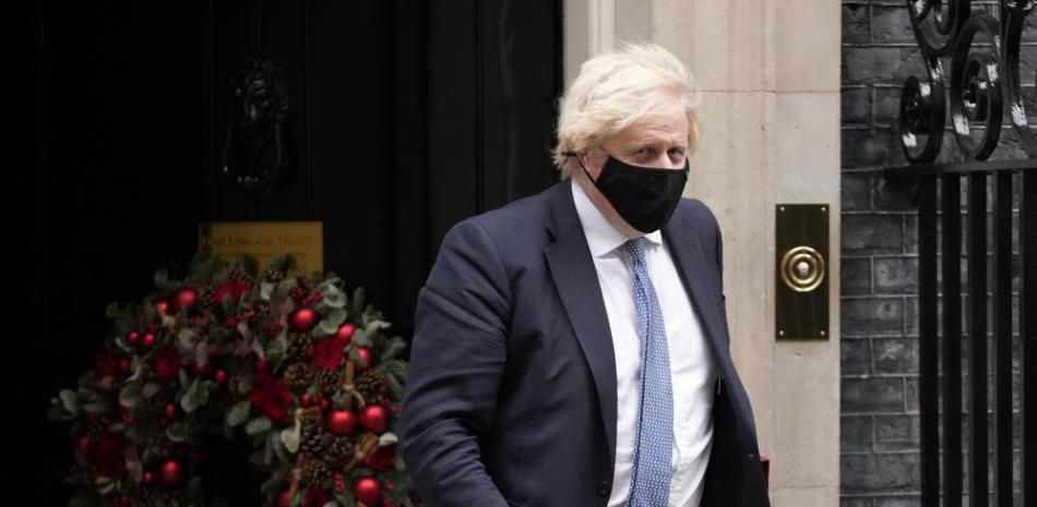 El primer ministro británico Boris Johnson sale de la residencia oficial de 10 Downing Street para asistir a la sesión semanal de preguntas en la Cámara de los Comunes, Londres, miércoles 8 de diciembre de 2021.