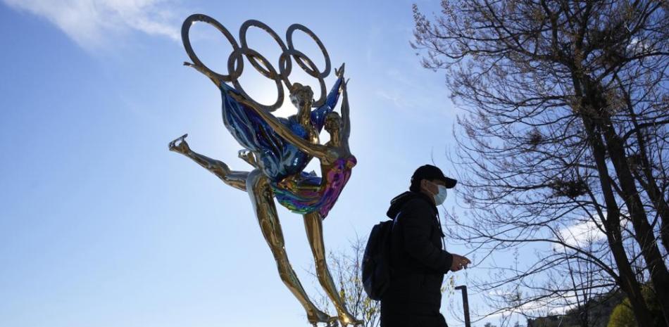 Un visitante pasa junto a una escultura por los Juegos Olímpicos de Invierno de Beijing, en el parque Shougang, en Beijing, China, el 9 de noviembre de 2021.