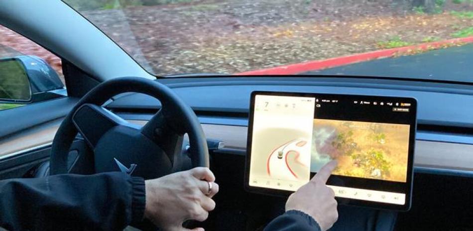 Vince Patton, propietario de un auto Tesla, demuestra el miércoles 8 de diciembre de 2021, en una camino cerrado en Portland, Oregon, cómo puede jugar videojuegos en la consola del vehículo mientras conduce.

Foto: AP/Gillian Flaccus