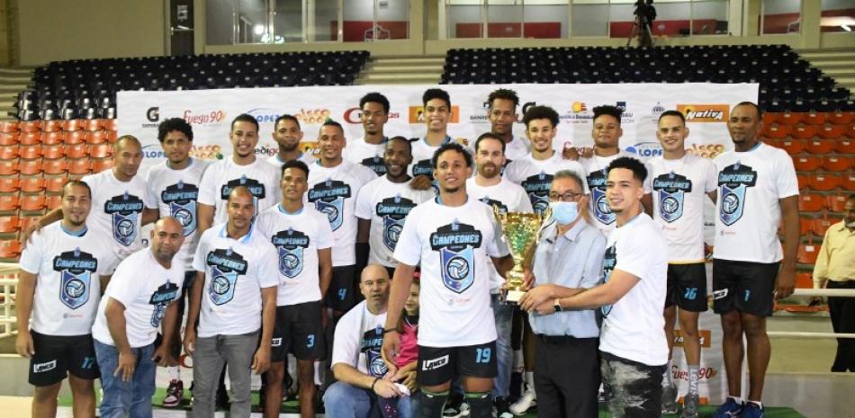 El licenciado Ángel Rivas, presidente de la Asociación de Voleibol de Distrito Nacional entrega el trofeo de campeón al Más Valioso Héctor Alexis Cruz y a todo el equipo de los Guerreros de Santo Domingo.
