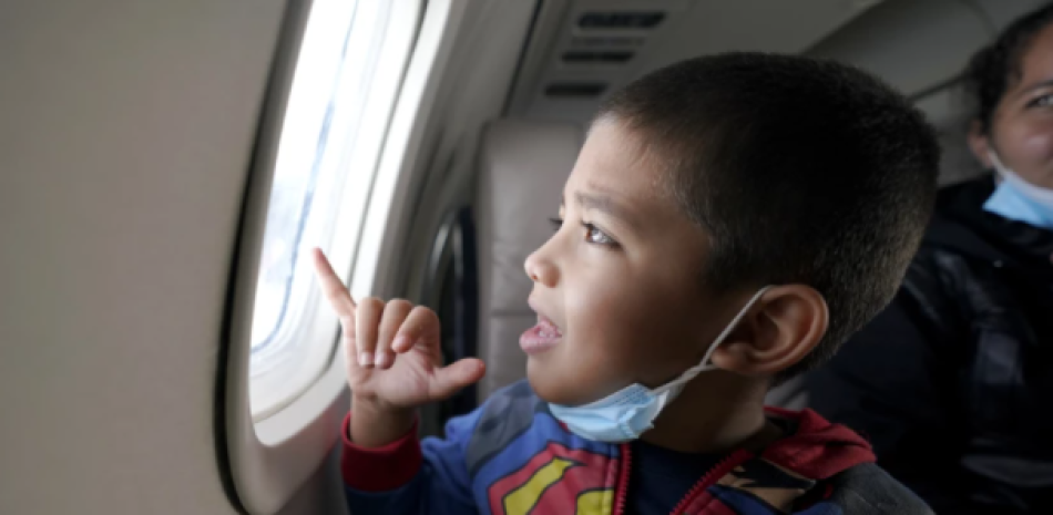 Yancarlos Amaya, un niño migrante hondureño de 5 años, se asoma por la ventanilla de un avión, en Harlingen, Texas, cuando él y su madre, Celestina Ramírez, viajaban a Houston. 
(Julio Cortez / Associated Press)