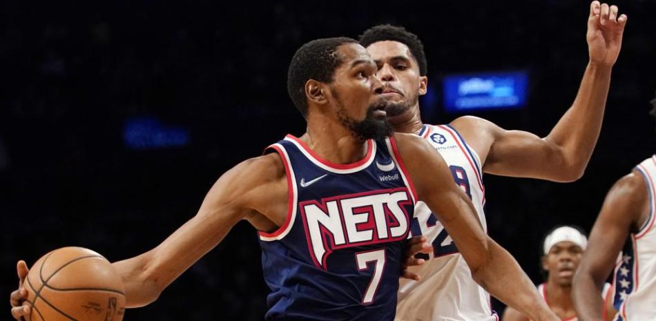 El alero de los Brooklyn Nets Kevin Durant (7) impulsa hacia la canasta contra el alero de los Philadelphia 76ers Tobias Harris (12) durante la segunda mitad de un juego de baloncesto de la NBA, el jueves 16 de diciembre de 2021 en Nueva York.