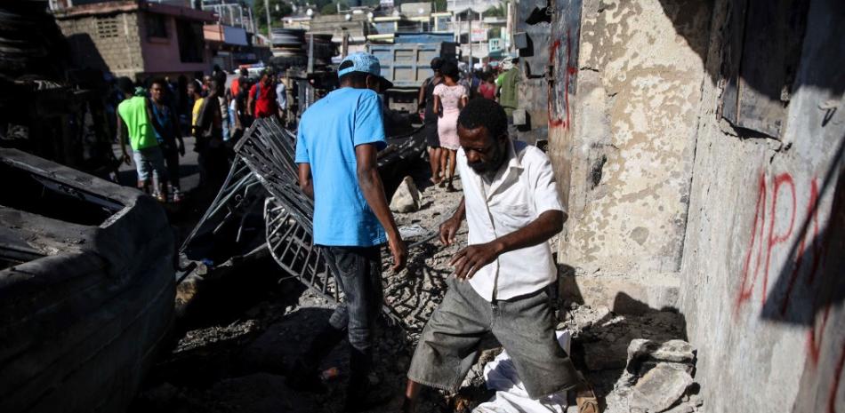 Un hombre pasa por encima de un cadáver cubierto por una sábana en Cap-Haitien, Haití, el 15 de diciembre de 2021. Cuatro personas heridas en una explosión masiva de un camión de gas en Haití murieron, elevando el número de muertos por el accidente a 66, dijeron las autoridades. Miércoles.
Foto: Richard Pierrin / AFP
