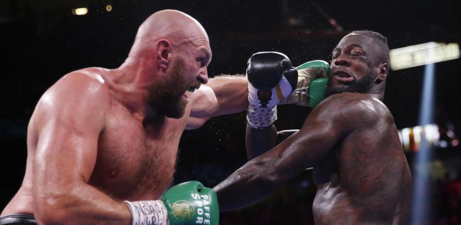 Tyson Fury conecta una zurda a Deontay Wilder en la pelea por el cetro de los pesos pesados.