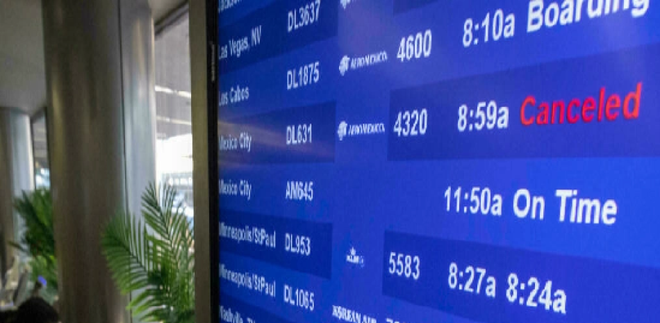 Viajeros ante las informaciones de vuelos en el aeropuerto internacional de Los Ángeles, el 24 de diciembre de 2021 DAVID MCNEW AFP